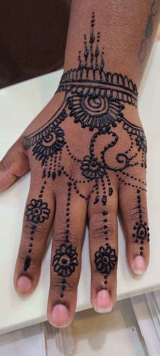 Intricate henna art across the hand and fingers